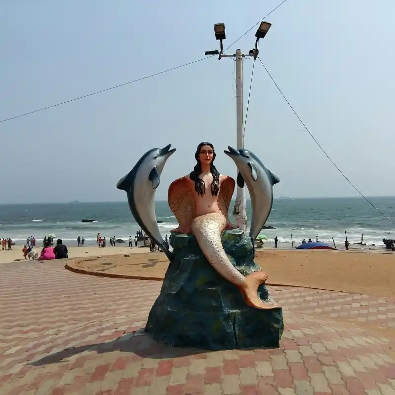 mermaid dolphin statue at rk beach vizag with tourists showing local expertise in vizag hotel market