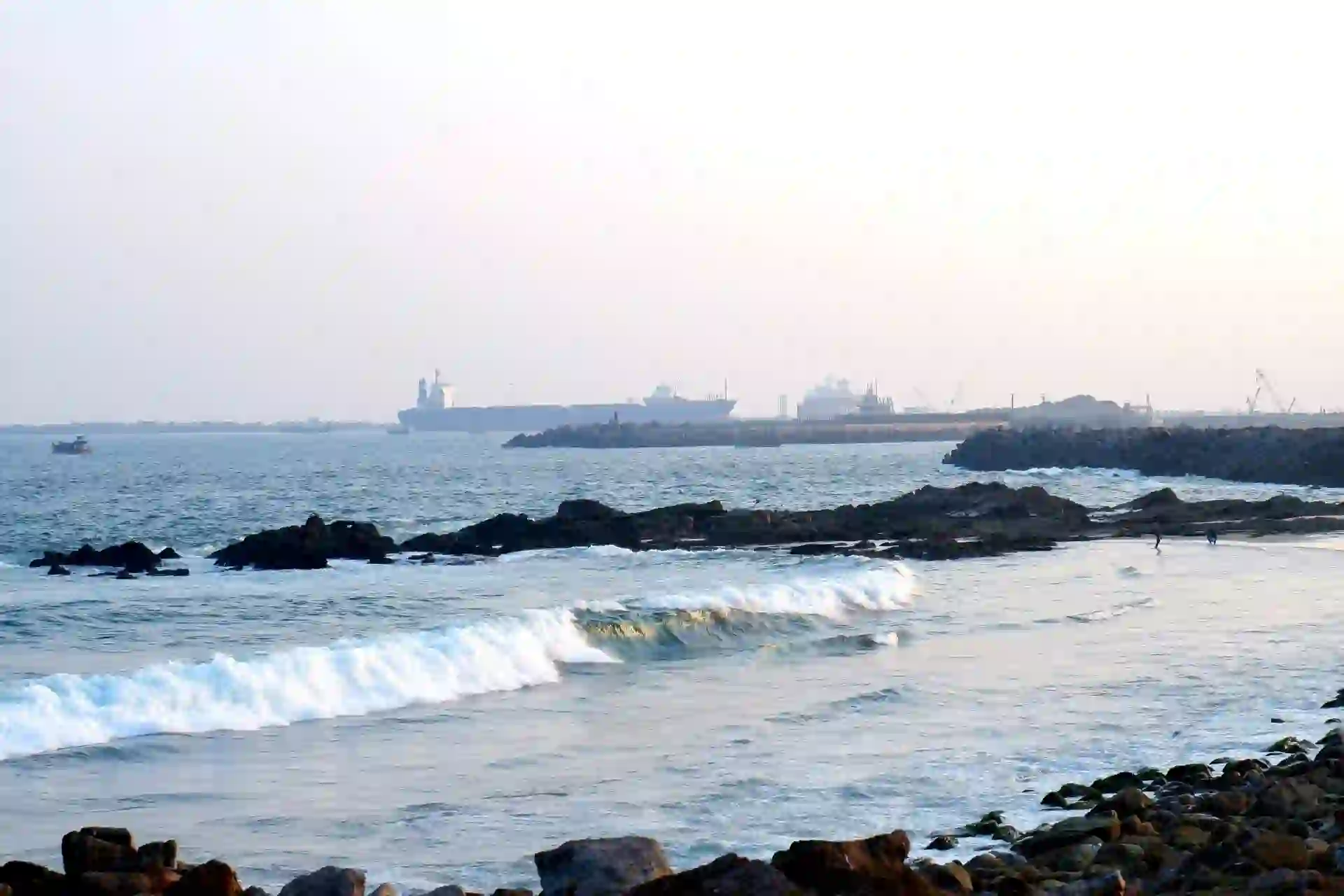 rk beach with sea waves and distant port view