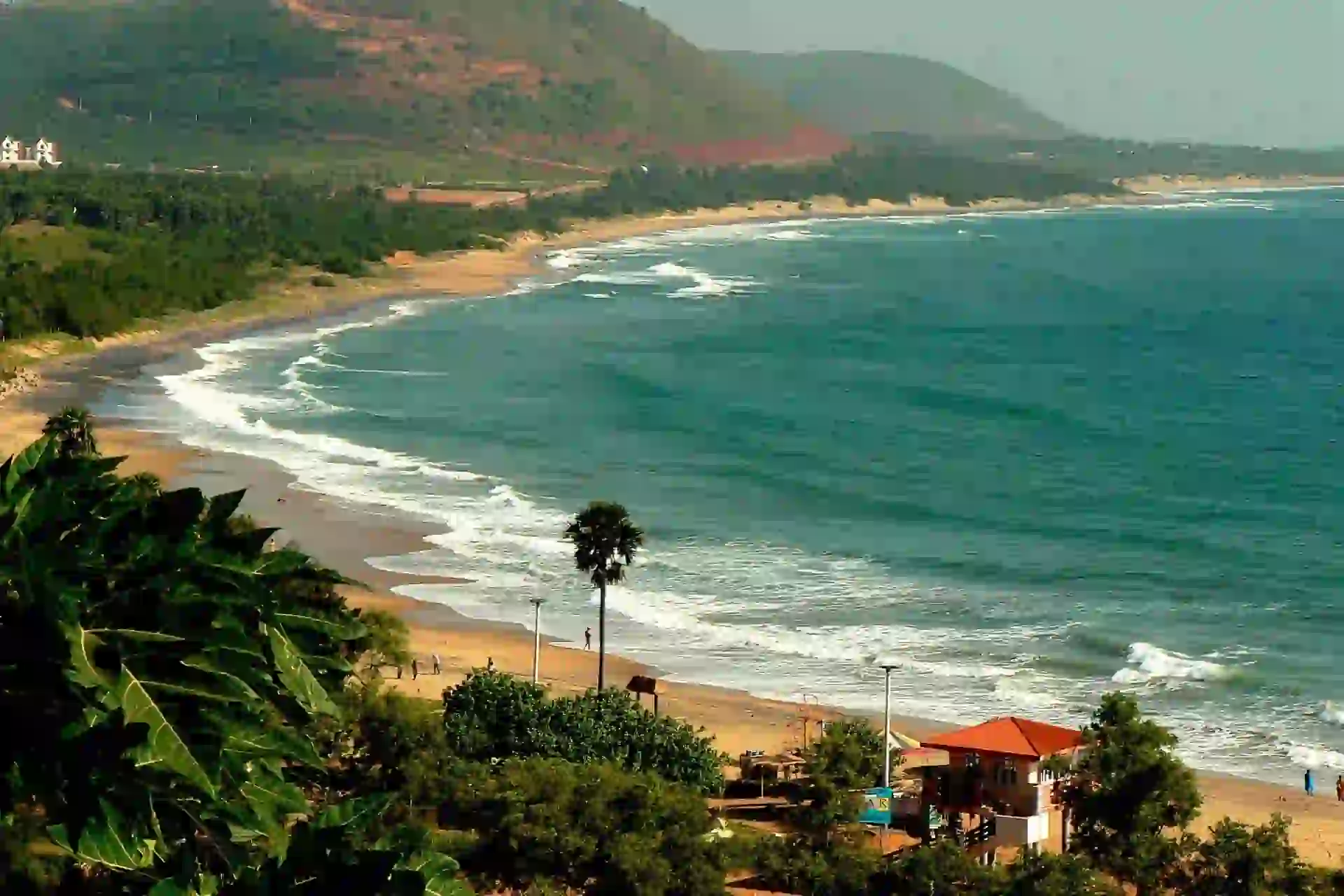 rushikonda beach with blue sea and mountain backdrop