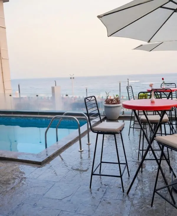 Swimming pool with sitting area and sea view at a hotel in Vizag
